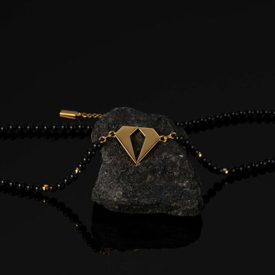 Elegante schwarze Perlenkette mit goldfarbenem Verschluss, detailreiche Nahaufnahme für Onlineshop